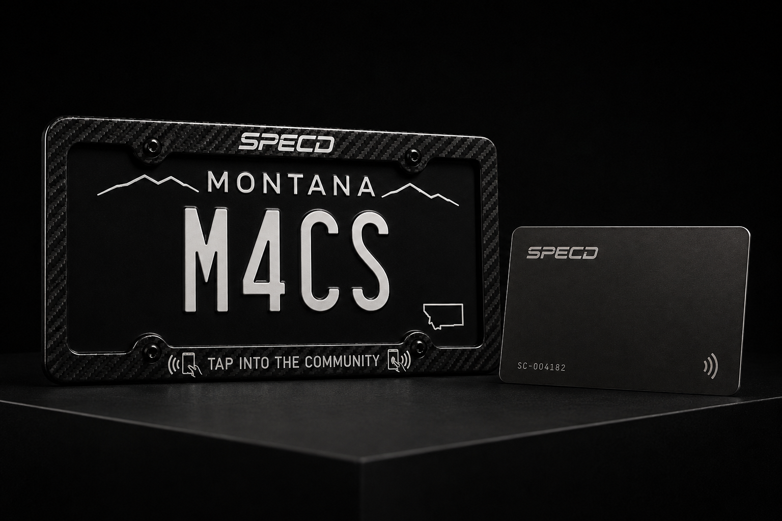 A carbon fibre SPECD license plate frame reading TAP INTO THE COMMUNITY, next to a black aluminium SPECD tap card.